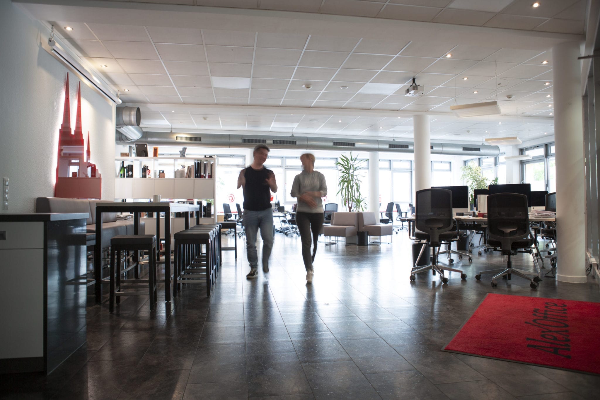 Zwei Menschen in einem Büro, die sich beim Gehen unterhalten