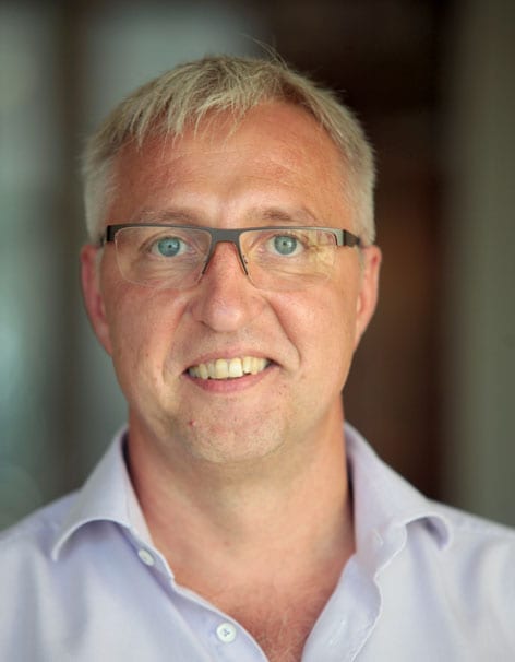 Foto von Falk Sawinski, Leitung der Alexianer Werkstaetten in Bickendorf Porträt eines lächelnden Mannes