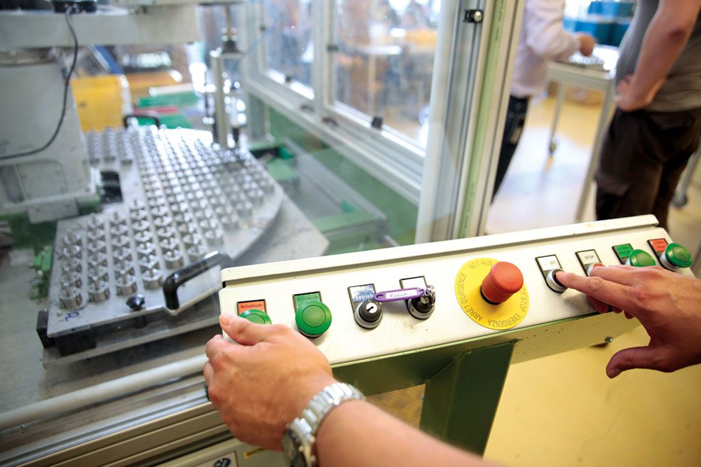 Alexianer-Werkstaetten-Bickendorf_Maschine-1 Porträt einer lächelnden Frau bei der Arbeit
