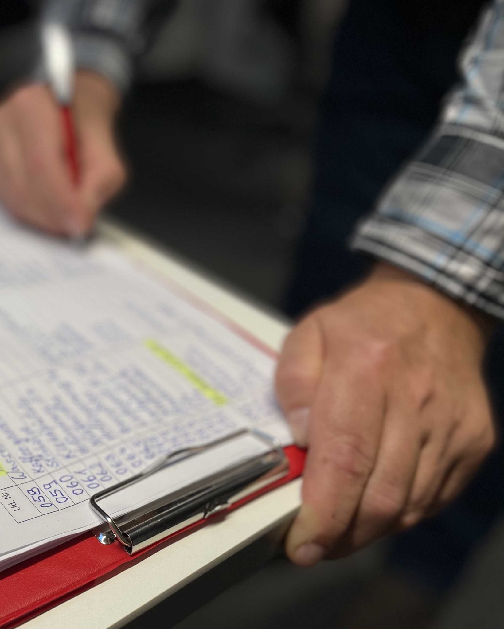 Prozessorientiertes Qualitätsmanagement nach DIN-Anforderungen. Jemand notiert Daten auf einem Blatt Papier.